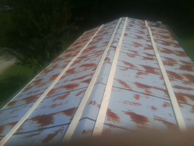 Rusted metal roof panels with new wood purlins before replacement — Storm Damage Roof Repair in Masury by Roofing Brothers