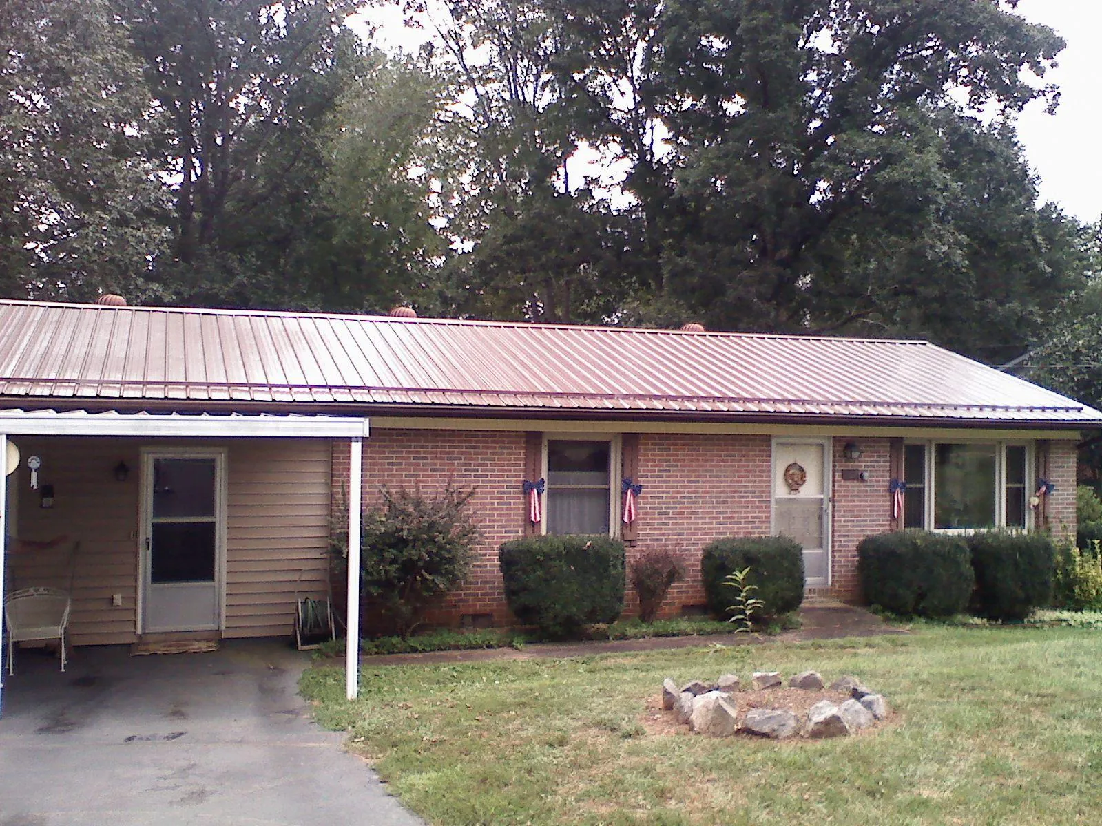 Bronze metal roof and carport on a brick ranch home — Roof Repair work by our crew in Masury